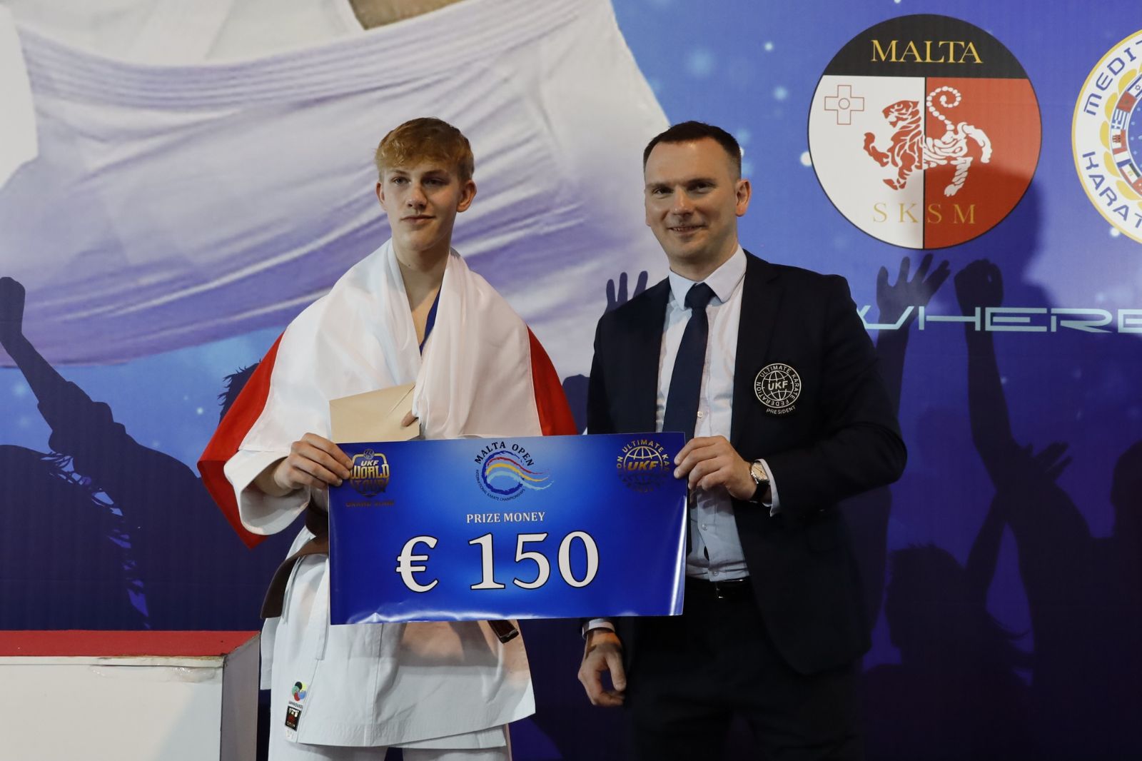 Paweł Juraszek wraz z trenerem Pawłem Bombolewskim i nagrodą finansową za zwycięstwo w konkurencji kata seniorów.jpg