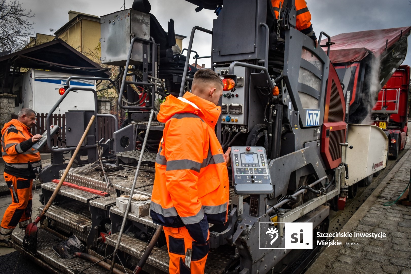 Na placu budowy panuje wzmożony ruch sprzętu drogowego.