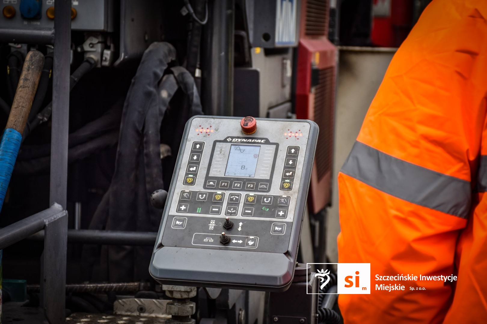 Na placu budowy panuje wzmożony ruch sprzętu drogowego.