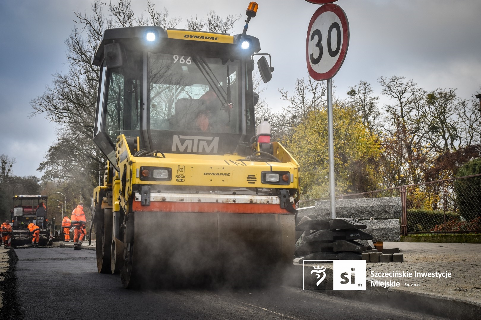Na placu budowy panuje wzmożony ruch sprzętu drogowego.