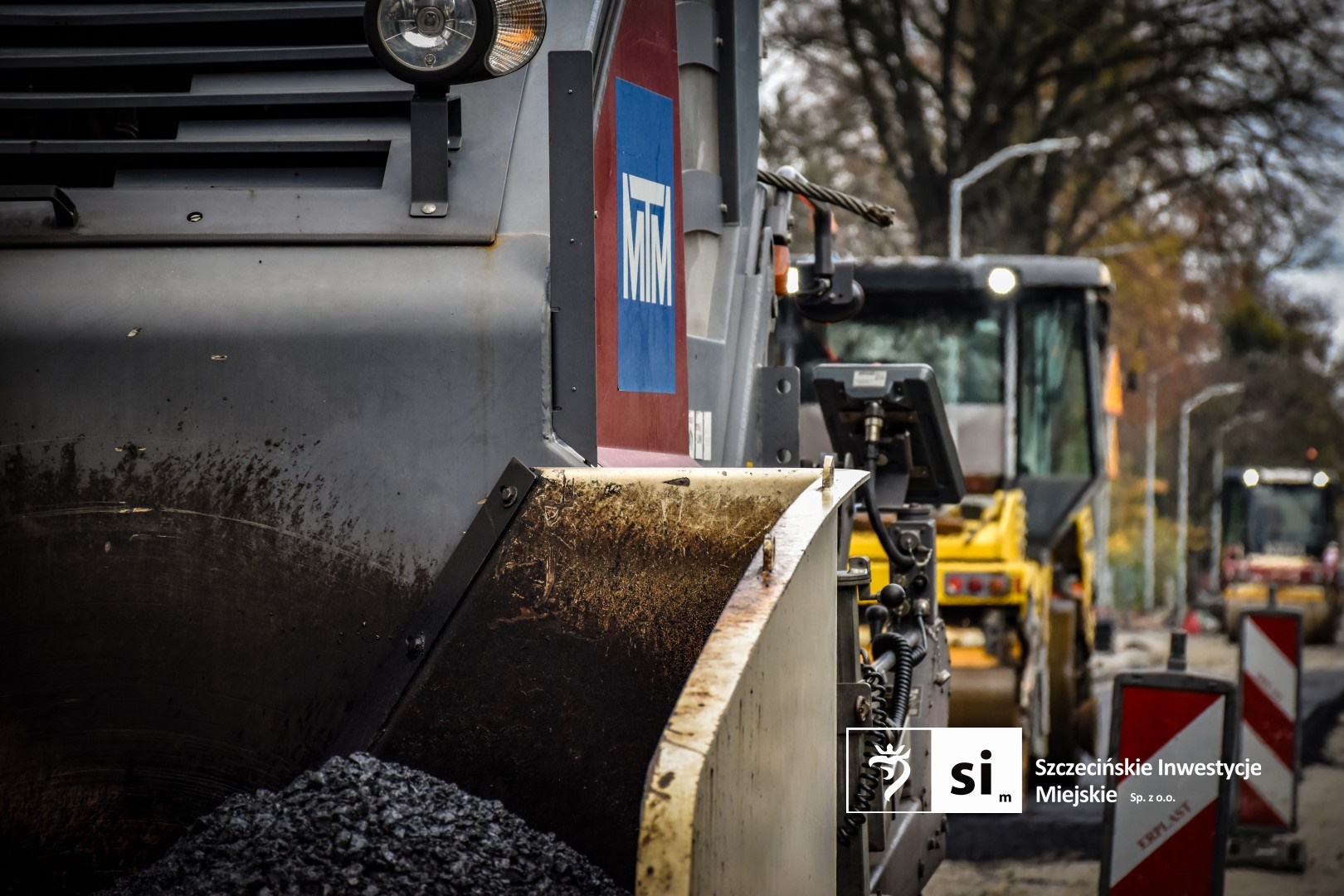 Na placu budowy panuje wzmożony ruch sprzętu drogowego.
