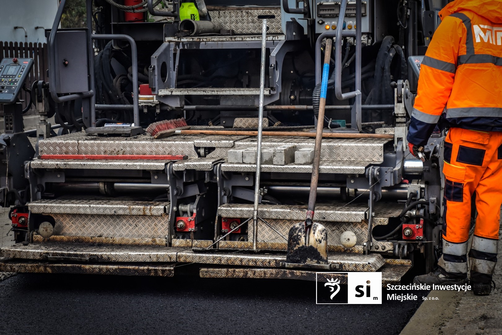 Na placu budowy panuje wzmożony ruch sprzętu drogowego.