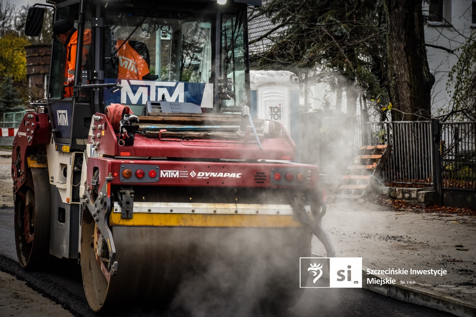 Na placu budowy panuje wzmożony ruch sprzętu drogowego.