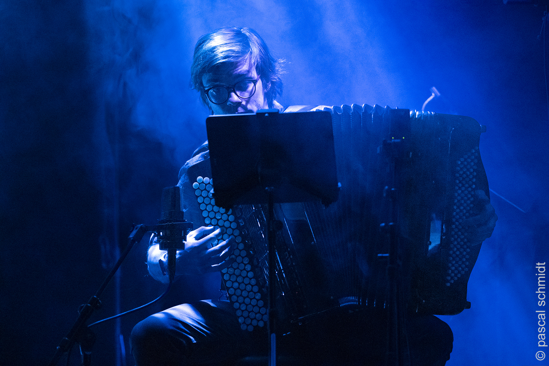 Grupa muzyków podczas koncertu, w niebieskiej poświacie. Grupa muzyków podczas koncertu, w niebieskiej poświacie.