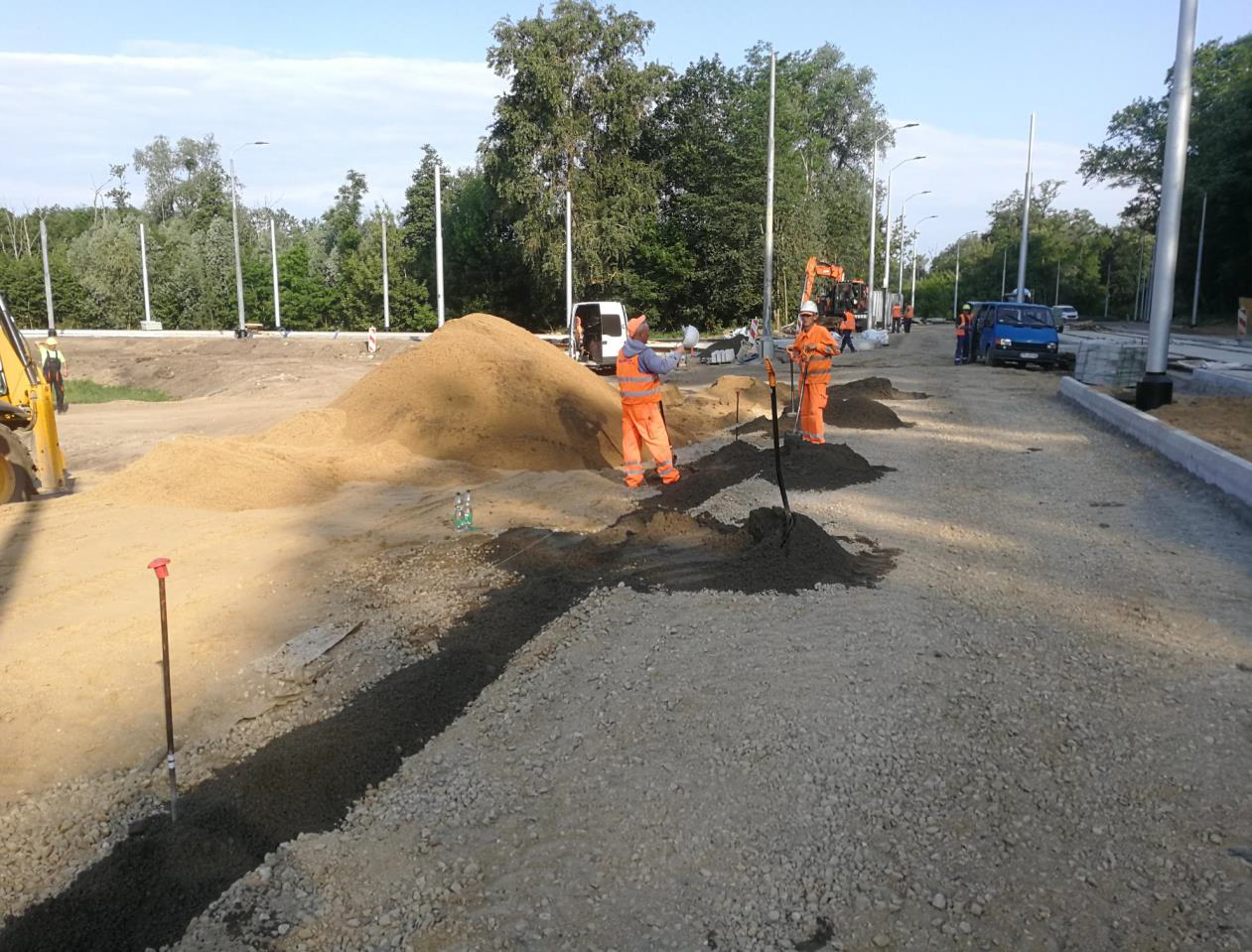 6. Ul. Arkońska – rejon pętli tramwajowej Las Arkoński – rozkładanie masy betonowej po ławę krawężnika.png