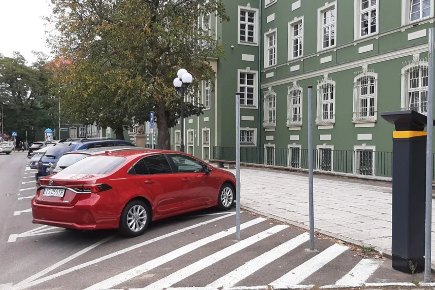 Czerwony samochód zaparkowany przy urzędzie miasta w Szczecinie
