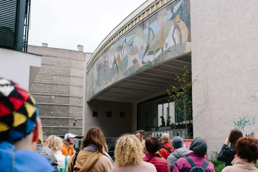 Grupa ludzi stojąca przed budynkiem