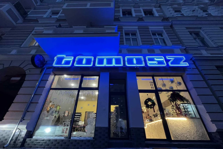 Neon z napisem tomasz nad witryną sklepową Neon z napisem tomasz nad witryną sklepową