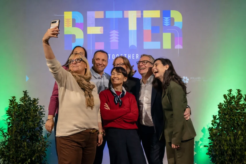 Grupa uśmiechniętych ludzi pozująca do zdjęcia.