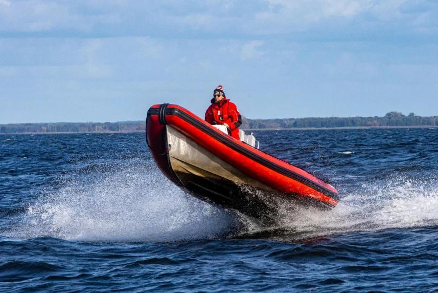 Czerwona motorówka na akwenie wodnym.