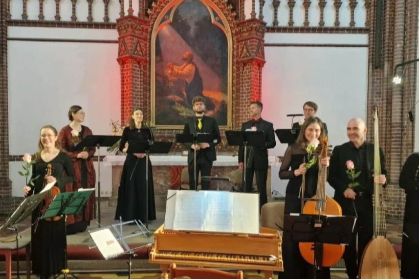 Grupa muzyków na tle ołtarza w kościele.