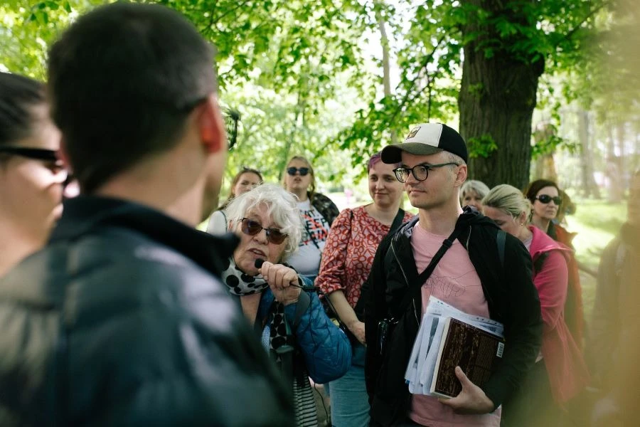 Grupa ludzi pod zielonym drzewem.