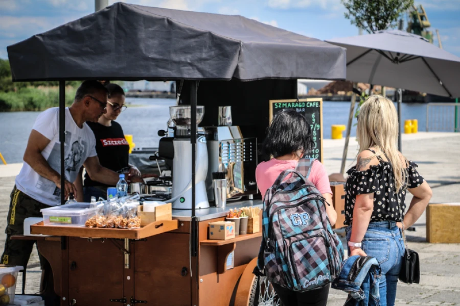 Z prawej dwie dziewczyny stojące przy punkcie gastronomicznym na Łasztowni.