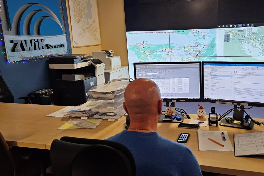 Mężczyzna siedzący przed monitorami komputerowymi w dyspozytorni ZWIK.
