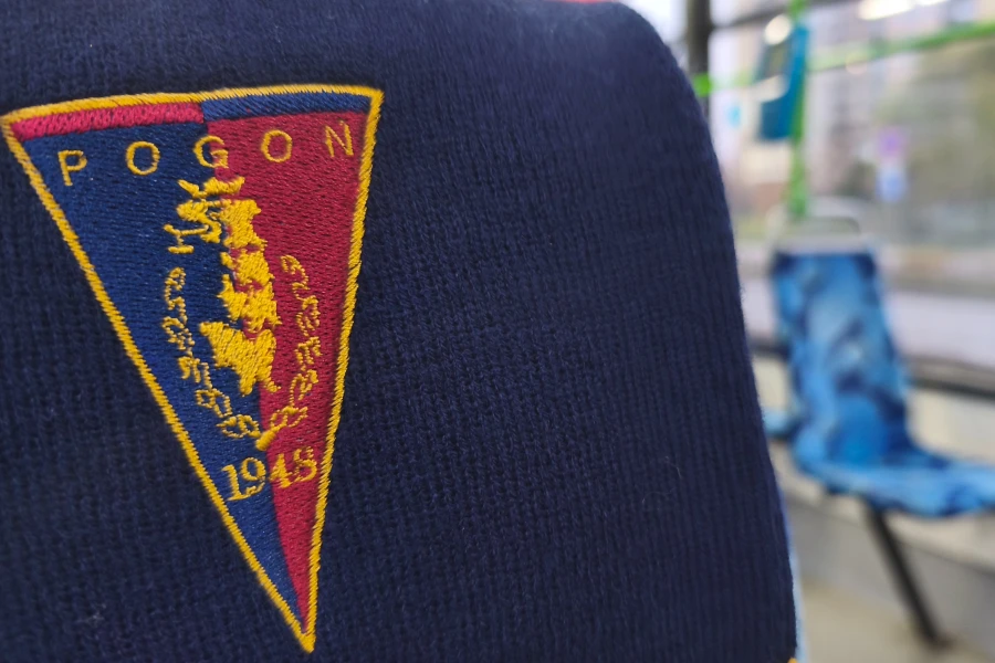 Szalik Pogoni Szczecin. W tle siedzisko tramwajowe.