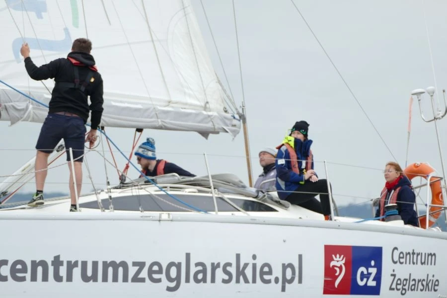 Grupa ludzi na białym jachcie.