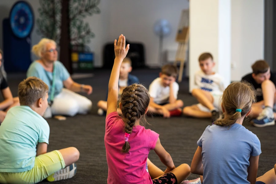 Grupa dzieci siedzących na podłodze.