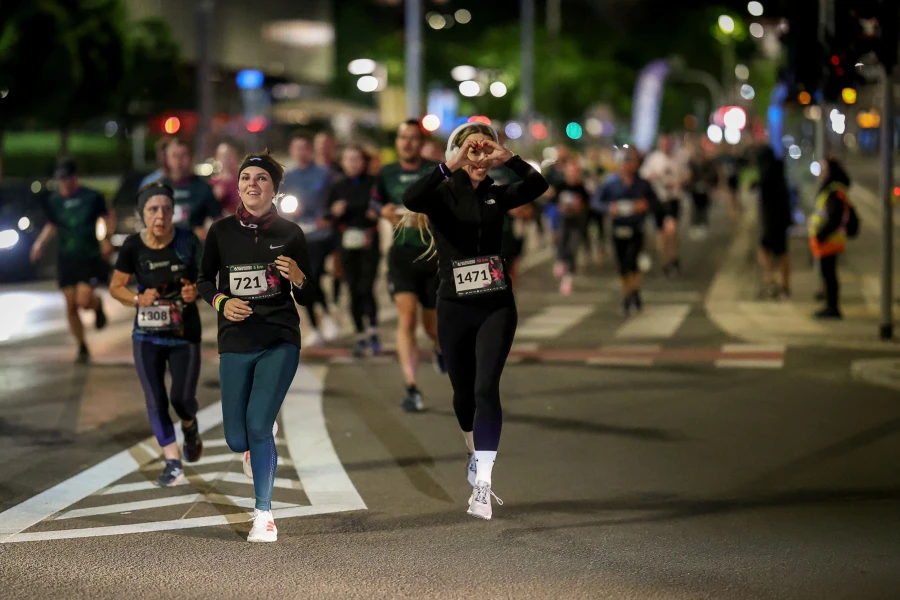 Grupa biegaczy podczas biegu nocnego na ulicach Szczecina.