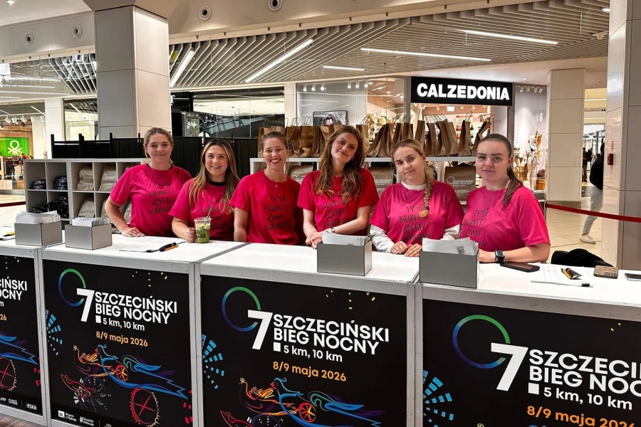 Sześć dziewczyn w różowych koszulkach w biurze zawodów.