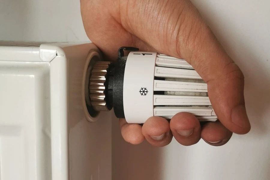 Męska dłoń na głowicy termostatycznej. Męska dłoń na głowicy termostatycznej.