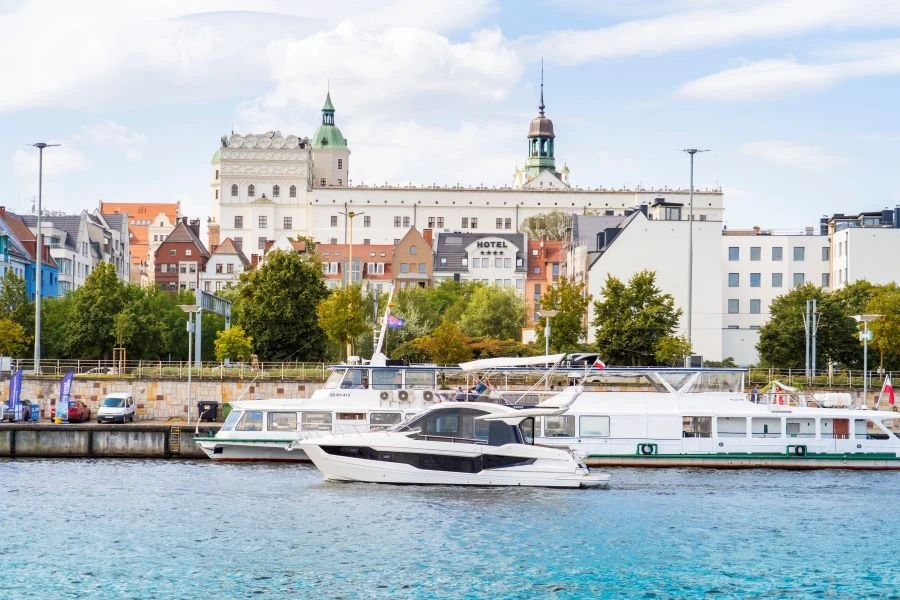Łódź motorowa i statek białej floty na tle Zamku Książąt Pomorskich w Szczecinie. Łódź motorowa i statek białej floty na tle Zamku Książąt Pomorskich w Szczecinie.