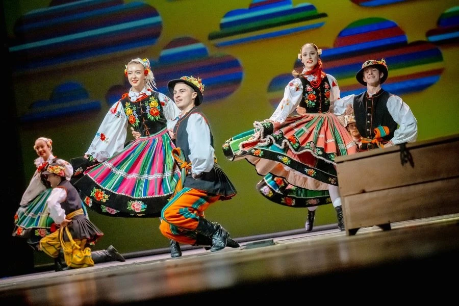 Grupa tancerzy ubranych w stroje regionalne.