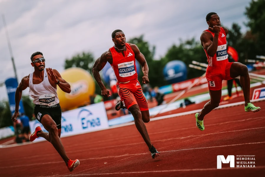 Trójka biegaczy w czasie biegu na stadionie. Trójka biegaczy w czasie biegu na stadionie.